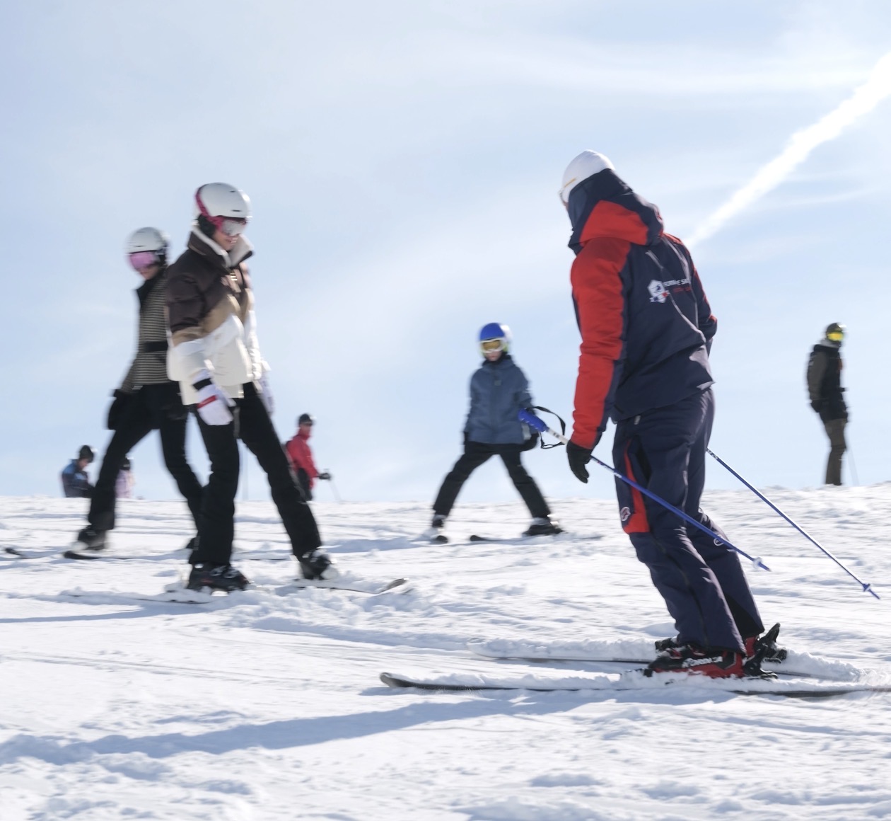 Grupo de alunos esquiando com monitor nos Alpes Franceses