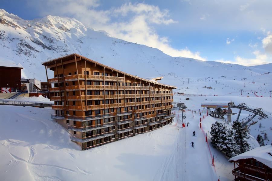 Residência de montanha coberta de neve com pista de ski ao lado